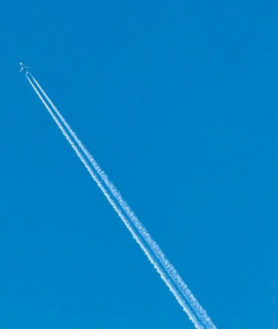 Aereo di linea in volo che lascia scie di condensazione, fenomeno legato all’impatto climatico dell’aviazione